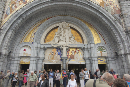 Lourdes, France, 24 June 2019: Little boy in front of the richly decorated entrance to the Rosary Basilica in Lourdest, France.のeditorial素材