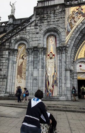 Lourdes, France, 24 June 2019: Mosaic of the studio of Marko Rupnik on the wall in front of the entrance to the Rosary Basilica in Lourdes.のeditorial素材