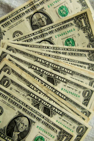 dollar bills of various denominations spread out on a flat surface as a background