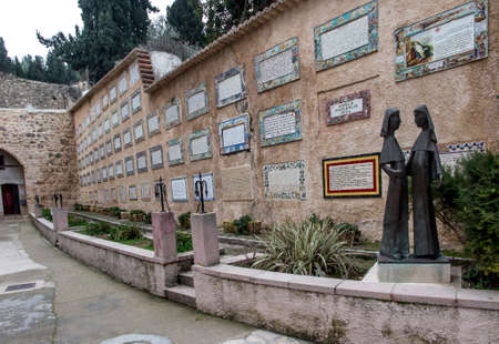 Ein Karem, ISRAEL - January 28, 2020: Figures of pregnant Mary and Elizabeth related to the visitation of Elizabeth by Mary in Ein Karem. In the background plates on the wall with the text of worship "Magnificat" in different languages.のeditorial素材