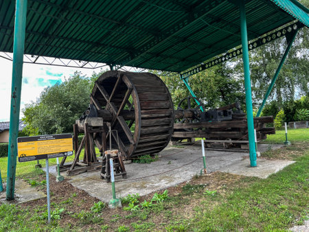 Tarnowskie Gory, Poland, August 7, 2023: An exhibition of old steam engines on the square next to the historic silver mine in Tarnowskie GÃ³ry. A water wheel driving a hammer in a forge.のeditorial素材