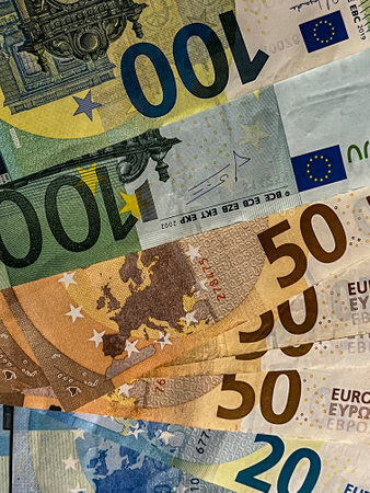 Euro banknotes of different denominations lying disorderly on the table.