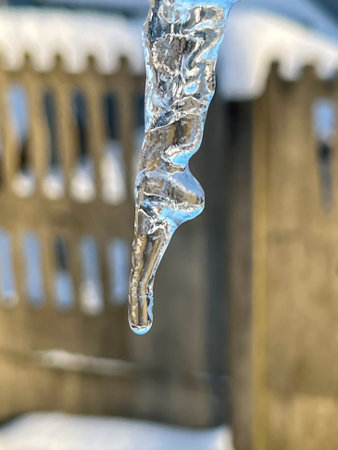 Icicle with water flowing down it, close-up.の写真素材