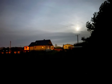 A wooden log house visible on a moonlit night.の写真素材