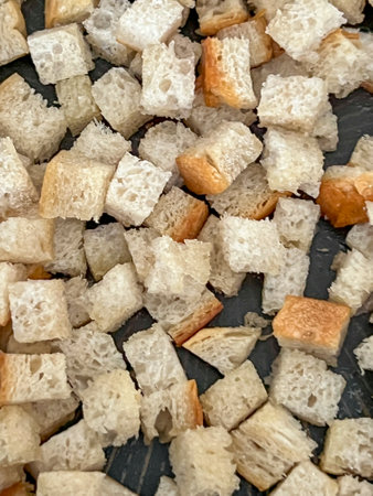 Pieces of sliced bread are fried in a pan with butter and garlic, and this is how croutons for...