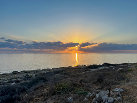 Sunset on Kissonerga beach in Paphos district of Cyprus on the Mediterranean Sea.の写真素材