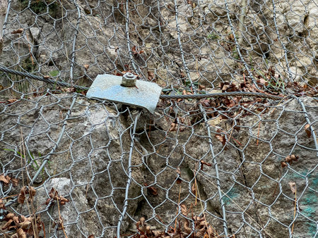 Protection of a rocky slope with a metal net against falling broken stones.の写真素材