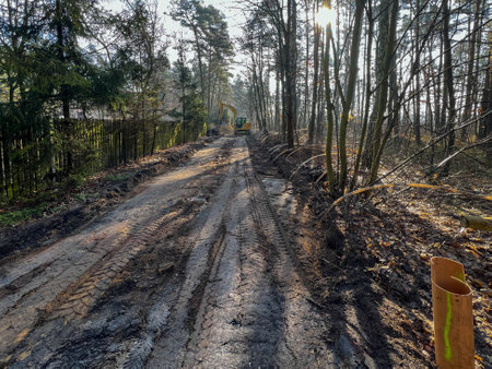 Fenced excavations in the ground along the road during construction of the sewage system. Excavator-bulldozer.の写真素材