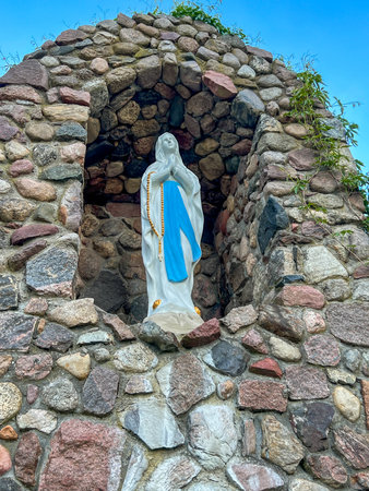 Figure of Mary in a grotto (similar to the one in Lourdes, France) in the garden of the Minor Basilica of Our Lady Listening Patiently in Rokitno.の写真素材