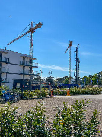 A construction site of an apartment building on the Baltic Sea in Mrzezyno, Poland with a crane and a machine for drilling holes in the ground (a huge drill).の写真素材