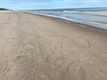Sand on the Baltic Sea beach in Mrzezyno in Poland after being washed by a wave in close-up as a background.の写真素材