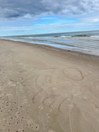 Sand on the Baltic Sea beach in Mrzezyno in Poland after being washed by a wave in close-up as a background.の写真素材
