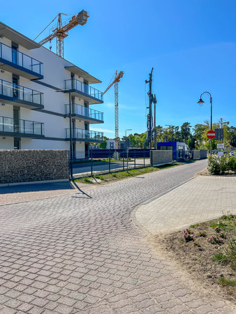 A construction site of an apartment building on the Baltic Sea in Mrzezyno, Poland with a crane and a machine for drilling holes in the ground (a huge drill).の写真素材
