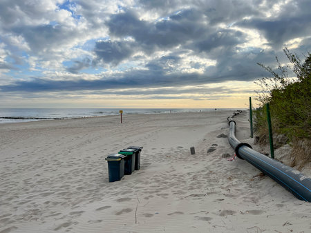 The eastern beach in Mrzezyno, Poland, with a pipe that is sometimes attached to the port dredger to drain sand from the dredging to the beach.の写真素材