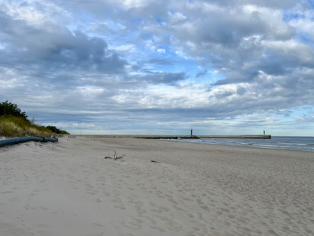 The eastern beach in Mrzezyno, Poland, with a pipe that is sometimes attached to the port dredger to drain sand from the dredging to the beach.の写真素材
