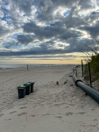 The eastern beach in Mrzezyno, Poland, with a pipe that is sometimes attached to the port dredger to drain sand from the dredging to the beach.の写真素材