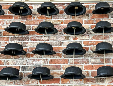Several hats and bowler hats against an unplastered brick wall, as decoration.の写真素材