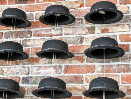 Several hats and bowler hats against an unplastered brick wall, as decoration.