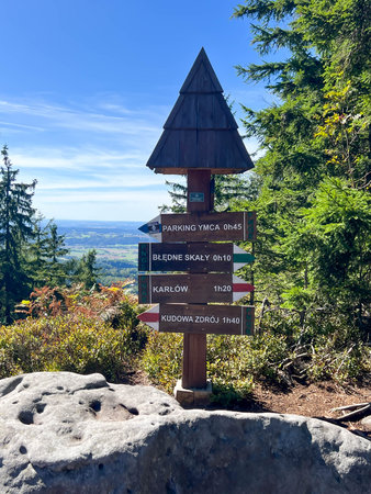 Bledne Skaly, Poland, September 4, 2025: A post with signs indicating distances to various places at the junction of hiking trails in the Bledne Skaly area in the Table Mountains (Gory Stolowe) in Poland.のeditorial素材