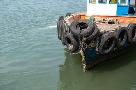Reuse of tires to be used as boat bumpers on the sea at local fisherman port near Pattaya, Thailand,...