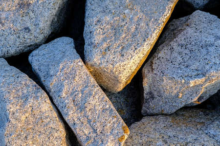 Close up. rock stone breakwater at the pier on the beach.