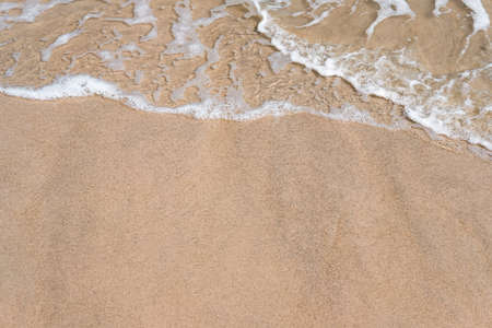 Close-up of wave on sandy beach with copy space for your text, top view background.の写真素材