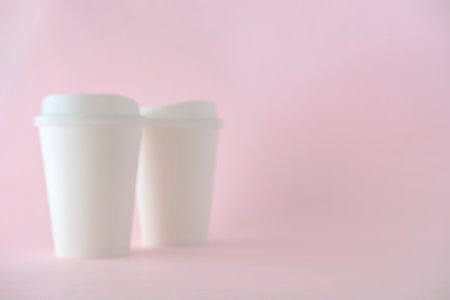 Blurred of White Paper Coffee Cup on Pink Background, Defocus Concept for Product Background.の写真素材