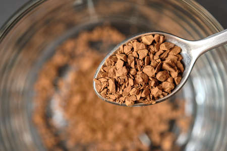Freeze Dried Instant Coffee on Tea Spoon with Glass Coffee Cup Background.の写真素材