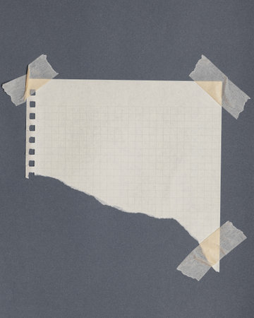 Torn graph paper with adhesive tape, scraps of paper on sticky tape, gray background.