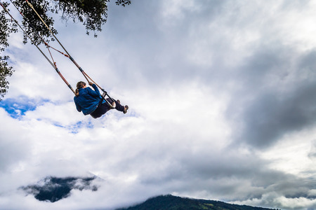 BaÃ±os - August 19, 2018: Tourists riding the famous Casa de Arbol End of the World swing in...