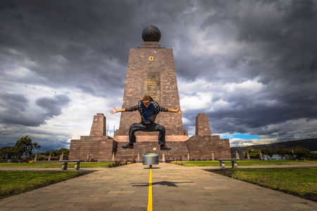 Mitad del Mondo - August 21, 2018: Tourist jumping in the Middle of the World monument in Mitad del Mondo, Ecuadorのeditorial素材