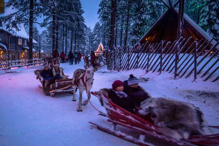 Rovaniemi - December 16, 2017: Tourists riding reindeers in Santa Claus village of Rovaniemi, Finlandのeditorial素材