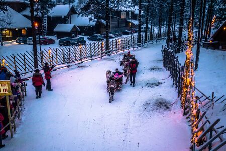 Rovaniemi - December 16, 2017: Tourists riding reindeers in Santa Claus village of Rovaniemi, Finlandのeditorial素材