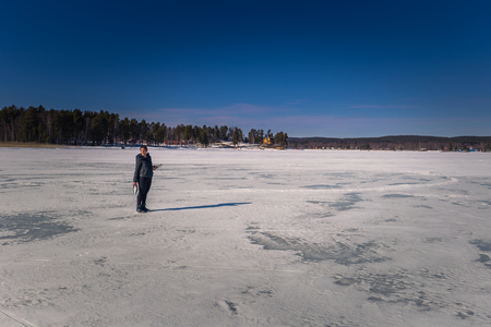Falun - March 31, 2018: Traveler hiking on the frozen lake at Framby Udde near the town of Falun in Dalarna, Swedenのeditorial素材
