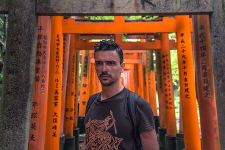 Kyoto - May 28, 2019: Western traveler in the Torii gates of the Fushimi Inari Shinto shrine in Kyoto, Japanのeditorial素材