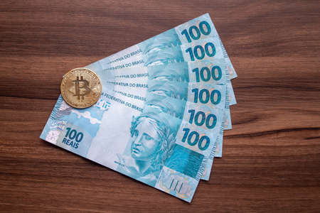 bitcoin symbol on top of brazilian real bank notes.の写真素材