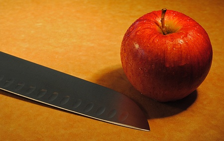 An apple and a knife on a cutting board.の写真素材