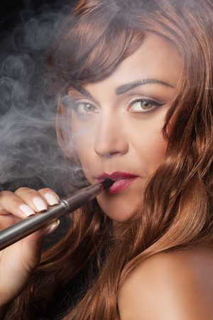 nude woman smokes a vape penの写真素材