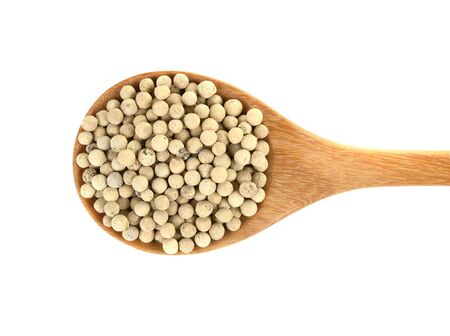 White pepper in wooden spoon on a white backgroundの写真素材