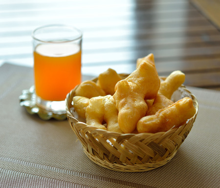 Deep-fried doughstick and orange juiceの写真素材