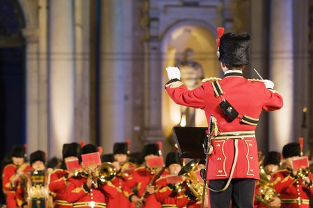 Conductor before british military band in the evening