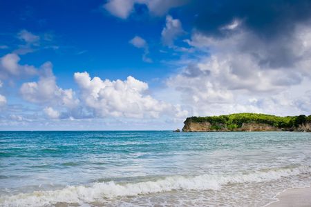 Stone cape in ocean with blue sky and cloudsの写真素材