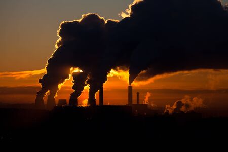 Factory of heat engineering chimney with clouds of streem in sky winter eveningのeditorial素材