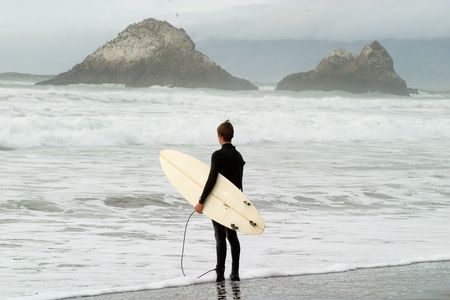Surfer contemplating the sea and ready to go into the waterの写真素材