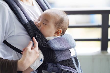 A mother and her five-month-old baby on a walk by baby carrier