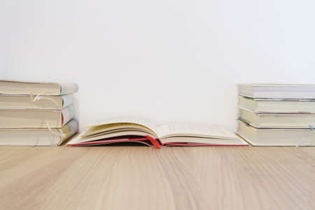 Piles of books on wooden desks and white walls