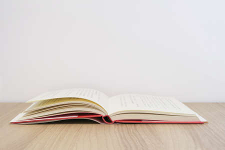 Open books and white walls at a wooden desk