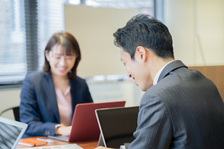 Three male and female businessmen having a meeting on a laptopの写真素材