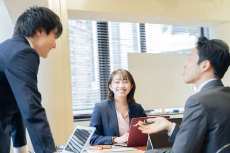 Three male and female businessmen having a meeting on a laptopの写真素材