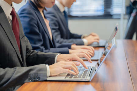 Three male and female businessmen having a meeting on a laptopの写真素材